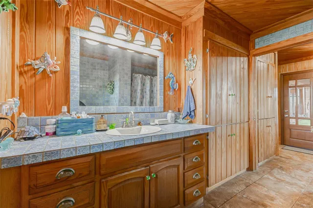 a large tree in front of a house with a garden