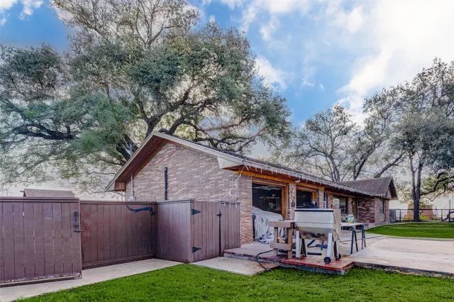 a view of a wooden bench sitting in middle of a yard