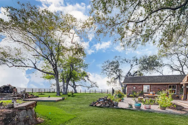 a big white house with a big yard and large trees