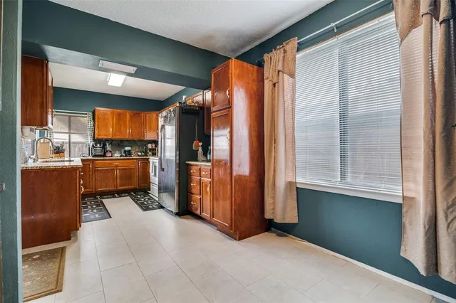 a view of kitchen with refrigerator and window