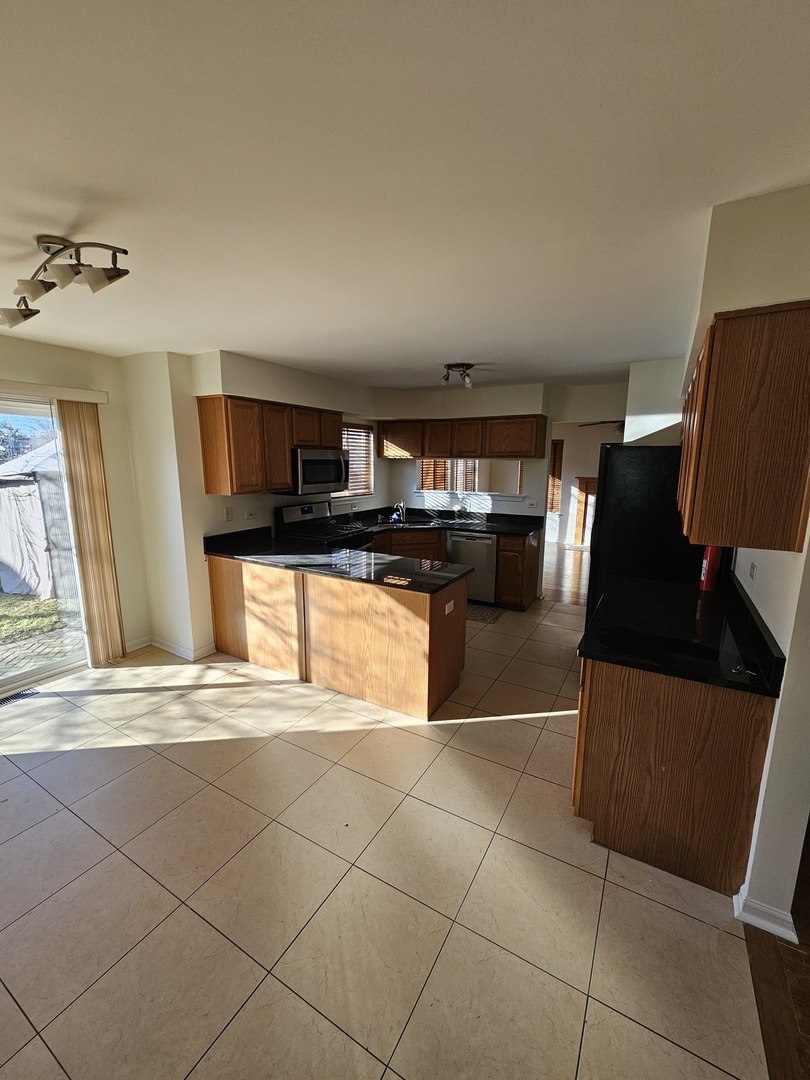 847 Teasel Lane Aurora, IL 60504 - Photo 12 of 46 a view of a refrigerator in kitchen and an empty room