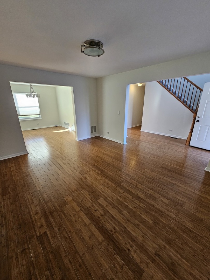 847 Teasel Lane Aurora, IL 60504 - Photo 9 of 46 a view of an empty room with wooden floor and a window