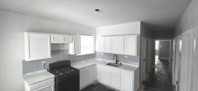 a kitchen with a sink stove and cabinets