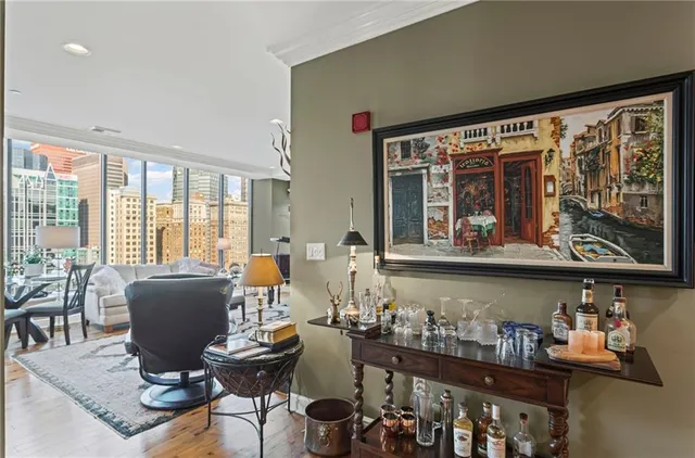 a view of a dining room and livingroom with furniture wooden floor a chandelier