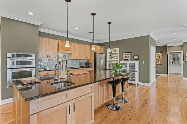 a kitchen with stainless steel appliances granite countertop a stove refrigerator and a wooden cabinets