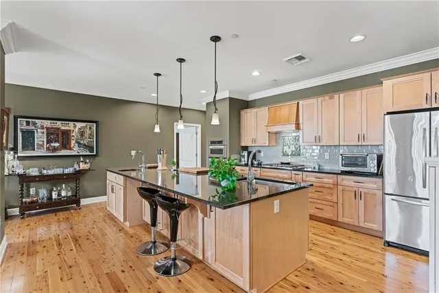 a kitchen with stainless steel appliances granite countertop a sink a stove and refrigerator