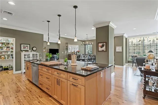 a kitchen with stainless steel appliances granite countertop a sink a stove and a wooden floors