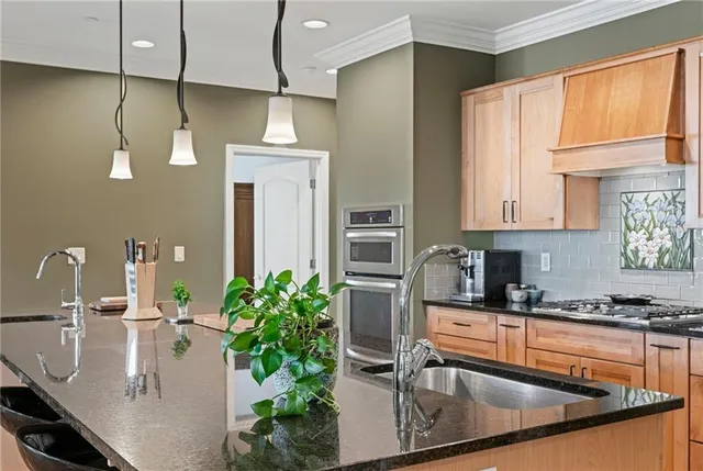 a kitchen with stainless steel appliances granite countertop a stove a sink and a microwave