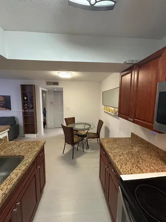 a kitchen with kitchen island granite countertop wooden cabinets and stainless steel appliances