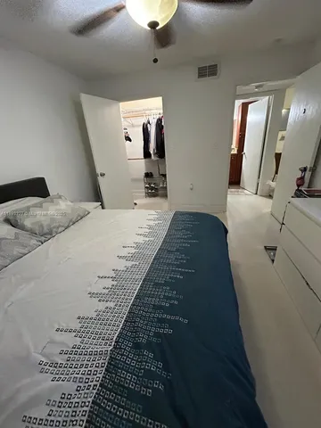 a spacious bedroom with a bed and a chandelier