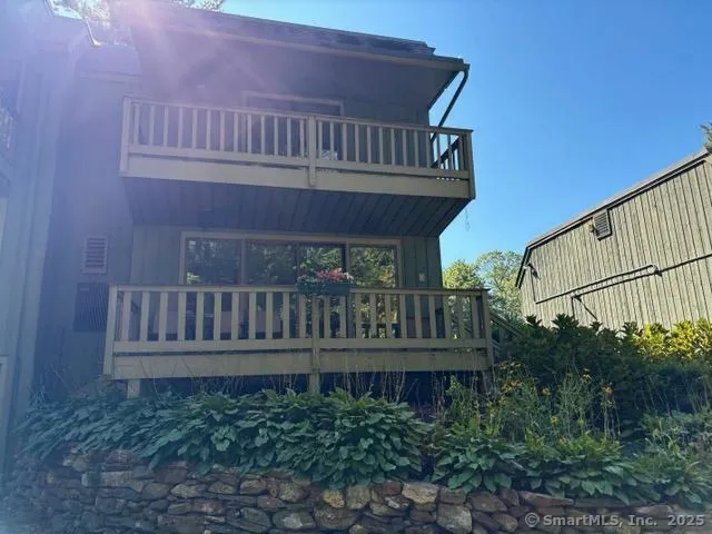 a view of a roof deck with chair and wooden fence