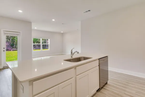a kitchen with a sink cabinets and wooden floor