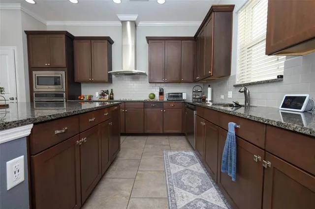 a kitchen with stainless steel appliances granite countertop wooden cabinets a sink and dishwasher