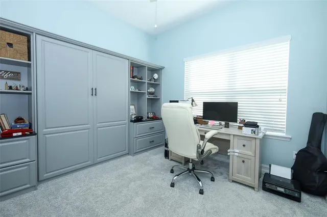 a view of a workspace with furniture and a window