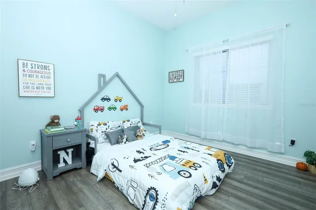 a bedroom with a bed and wooden floor