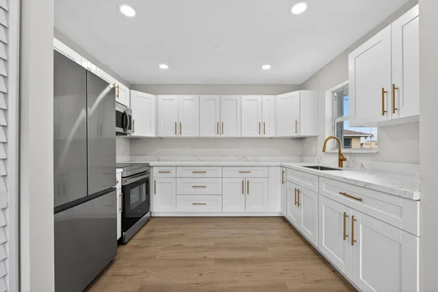 a kitchen with stainless steel appliances granite countertop a refrigerator and a stove top oven
