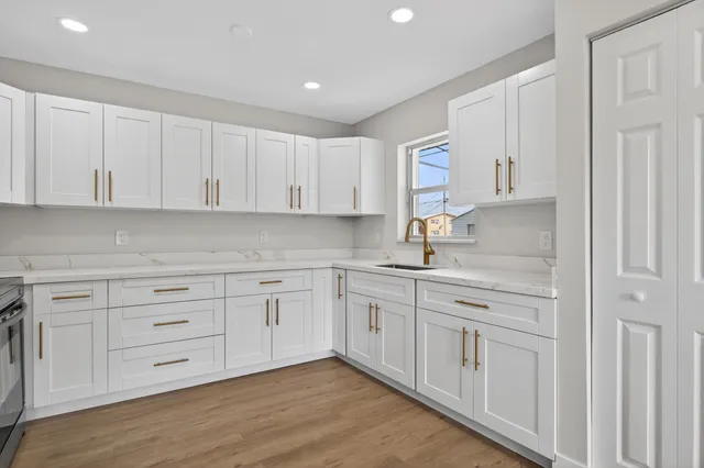 a kitchen with white cabinets and white appliances
