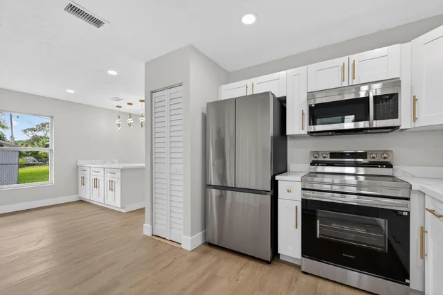 a kitchen with stainless steel appliances a stove a microwave and a refrigerator