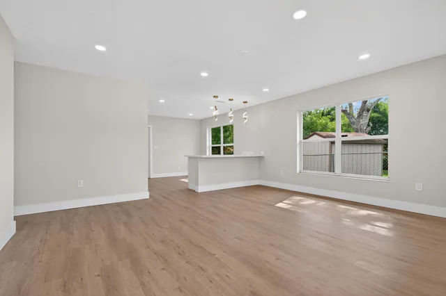 a view of a kitchen with wooden floor and a window