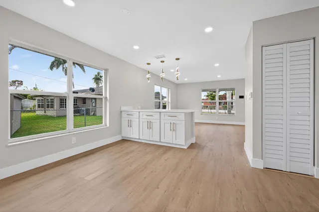 a view of an empty room with a window and wooden floor