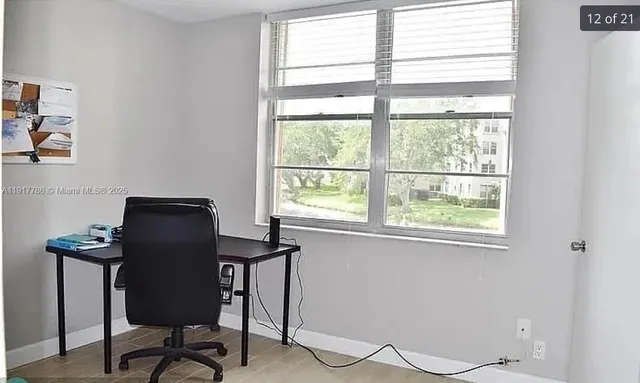 a view of a workspace with furniture and a window
