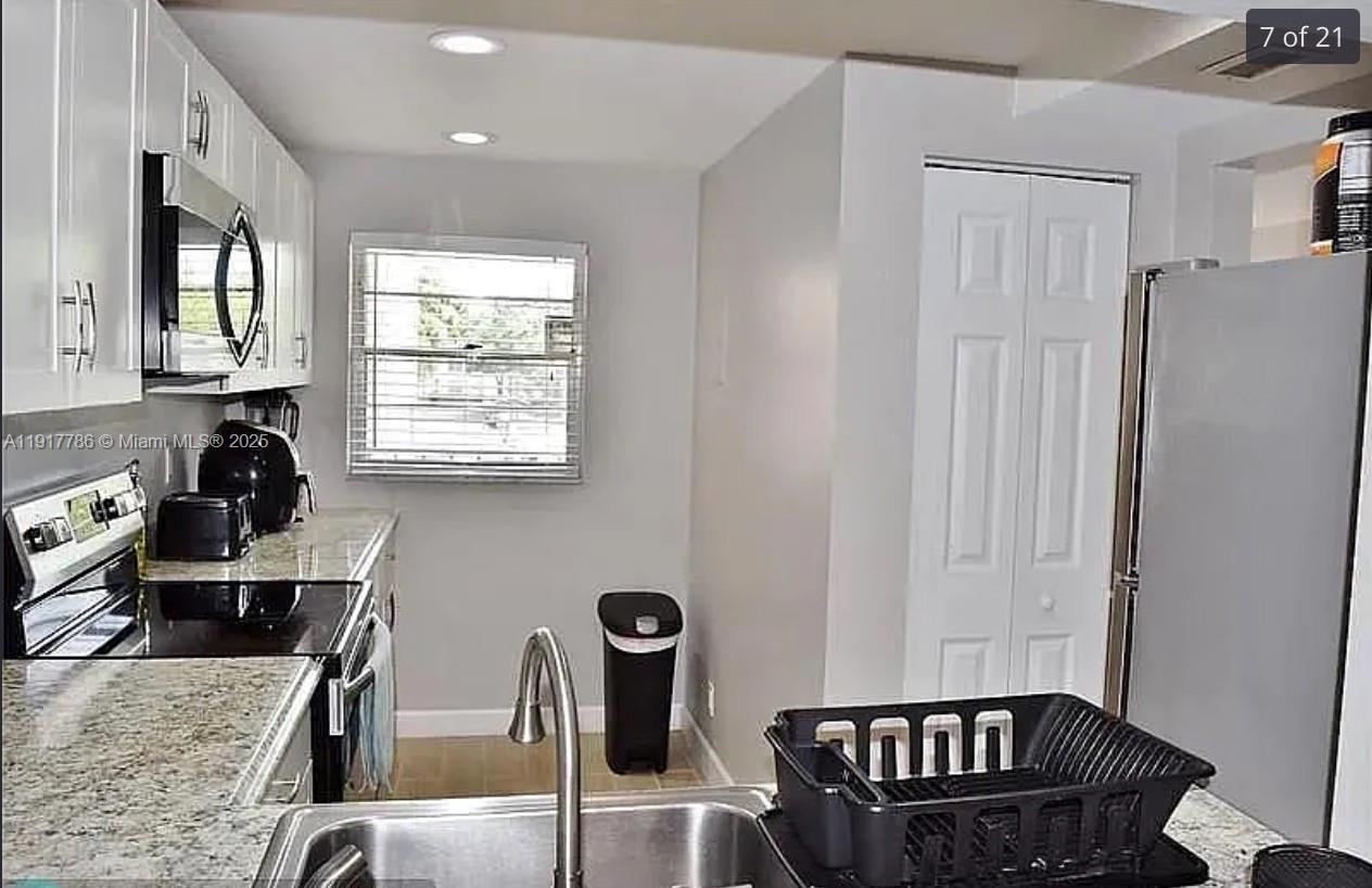 9230 Lagoon Place, Unit 215 Davie, FL 33324 - Photo 7 of 19 a kitchen with granite countertop a sink a stove and refrigerator