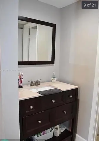 a bathroom with a granite countertop sink vanity and mirror
