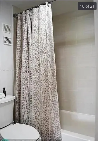 a white toilet sitting next to a shower curtain