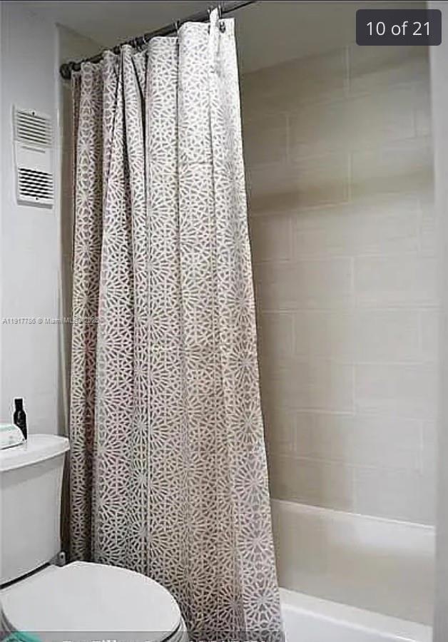 9230 Lagoon Place, Unit 215 Davie, FL 33324 - Photo 10 of 19 a white toilet sitting next to a shower curtain