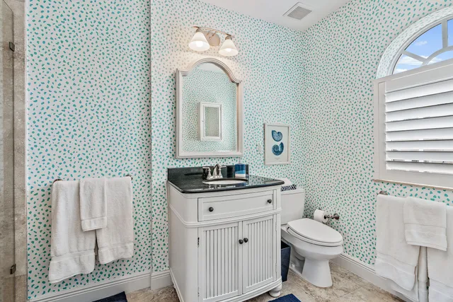 a bathroom with a toilet a sink and mirror