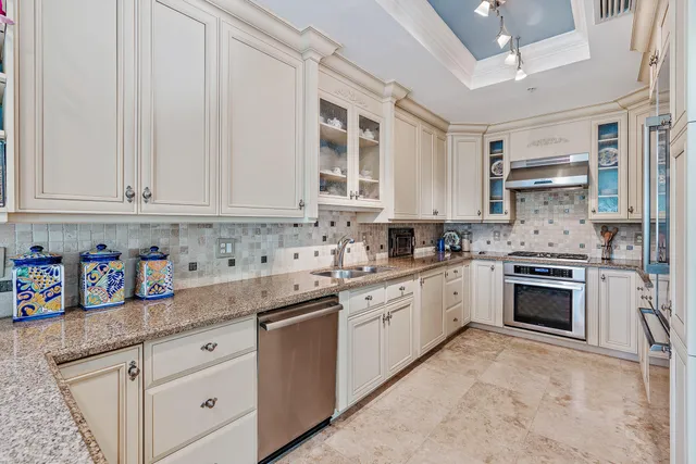 a kitchen with granite countertop white cabinets and white stainless steel appliances