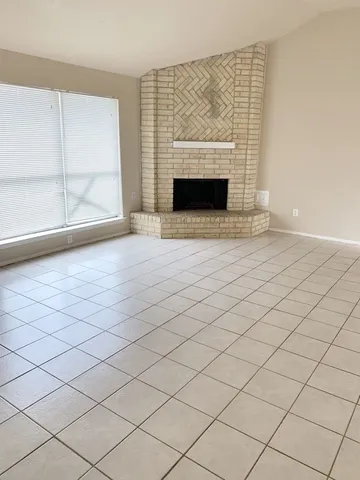 a view of empty room with wooden floor and fireplace