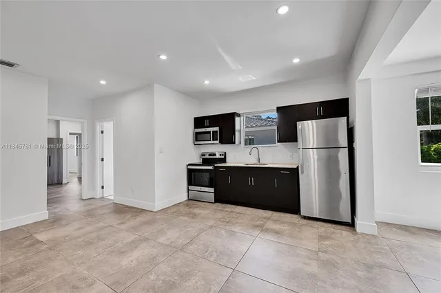 a large kitchen with a refrigerator and a sink