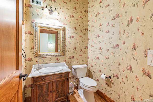 a bathroom with a granite countertop toilet sink and mirror