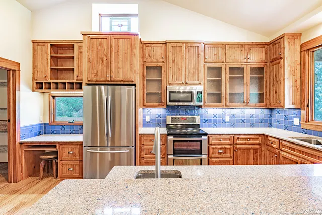 a kitchen with stainless steel appliances granite countertop a refrigerator a stove a sink and a microwave