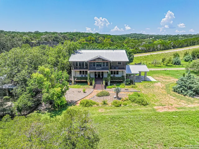 an aerial view of a house with swimming pool garden and patio