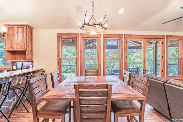a view of a dining room with furniture large windows and wooden floor