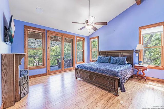 a spacious bedroom with a bed and wooden floor
