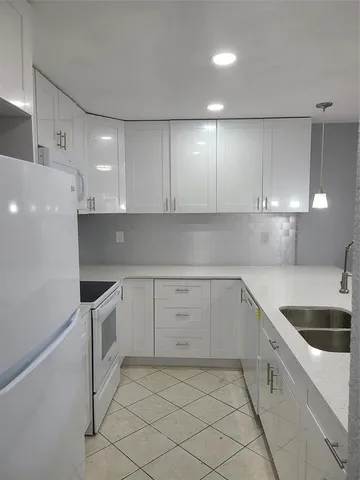 a kitchen with granite countertop white cabinets and white appliances