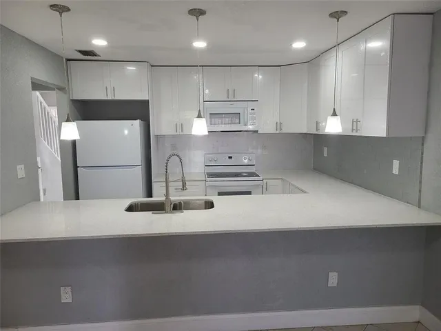 a kitchen with kitchen island a sink stainless steel appliances and cabinets