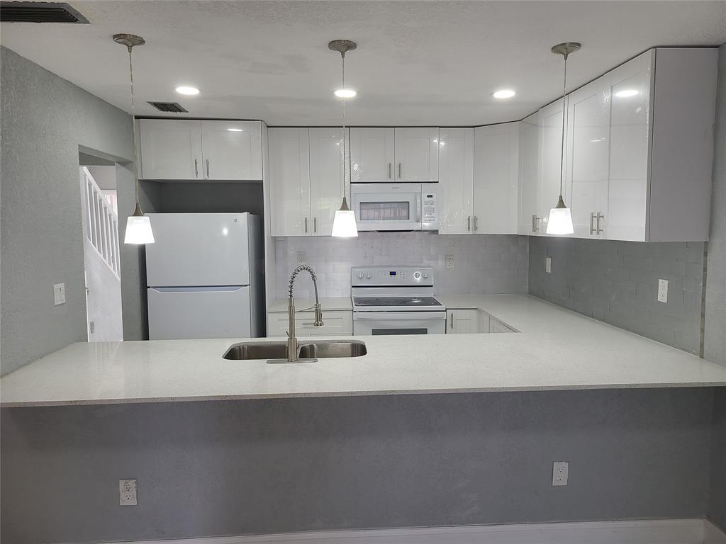 2775 Northwest 194th Terrace Miami Gardens, FL 33056 - Photo 25 of 37 a kitchen with kitchen island a sink stainless steel appliances and cabinets