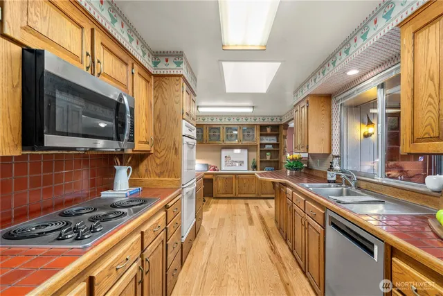 a large kitchen with stainless steel appliances granite countertop a stove and a sink