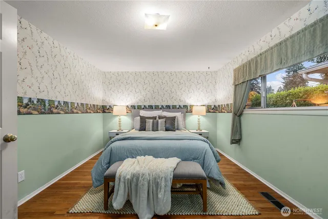 a bed sitting in a bedroom next to a window