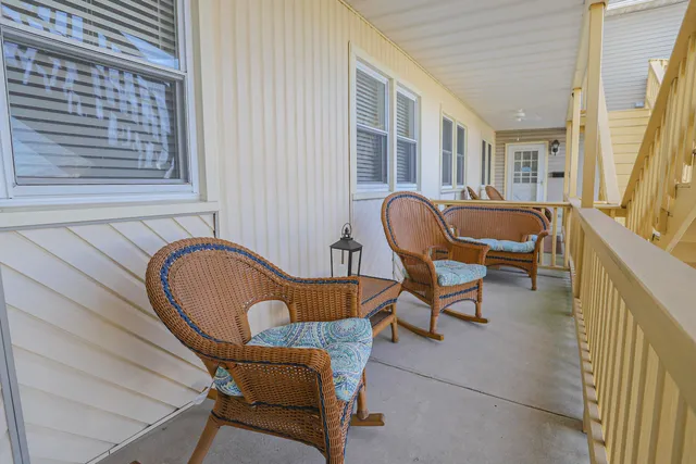 a balcony with chairs and a potted plant