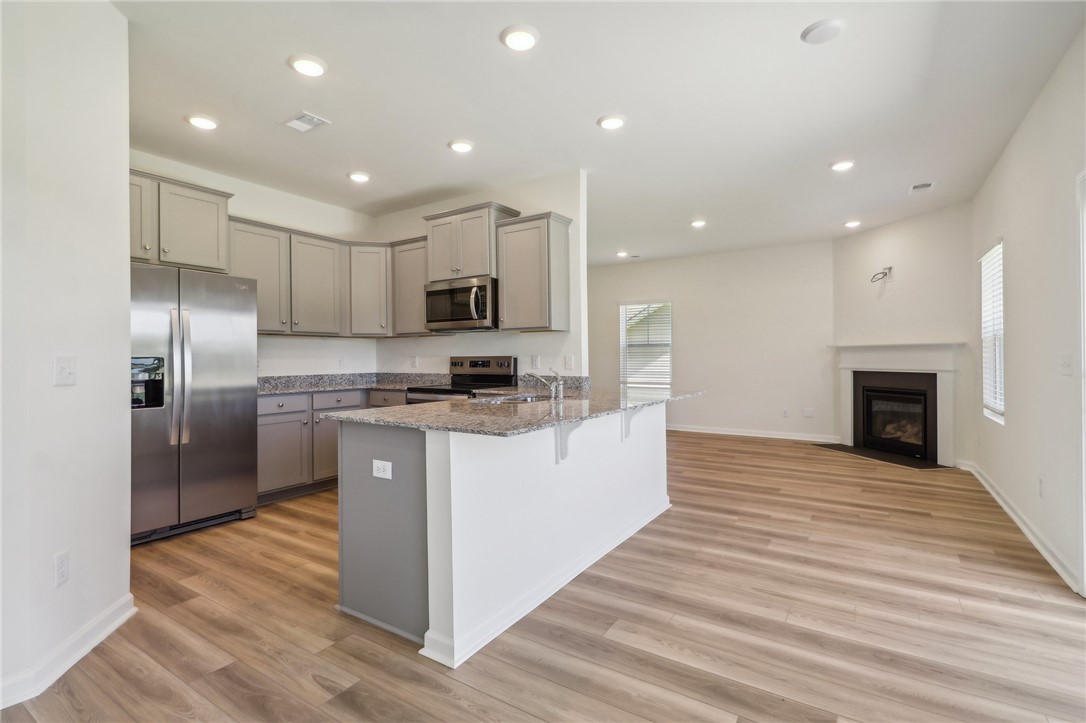 206 Bellflower Lane Pendleton, SC 29670 - Photo 2 of 27 This bright, open concept living area blends modern kitchen amenities with a cozy fireplace.