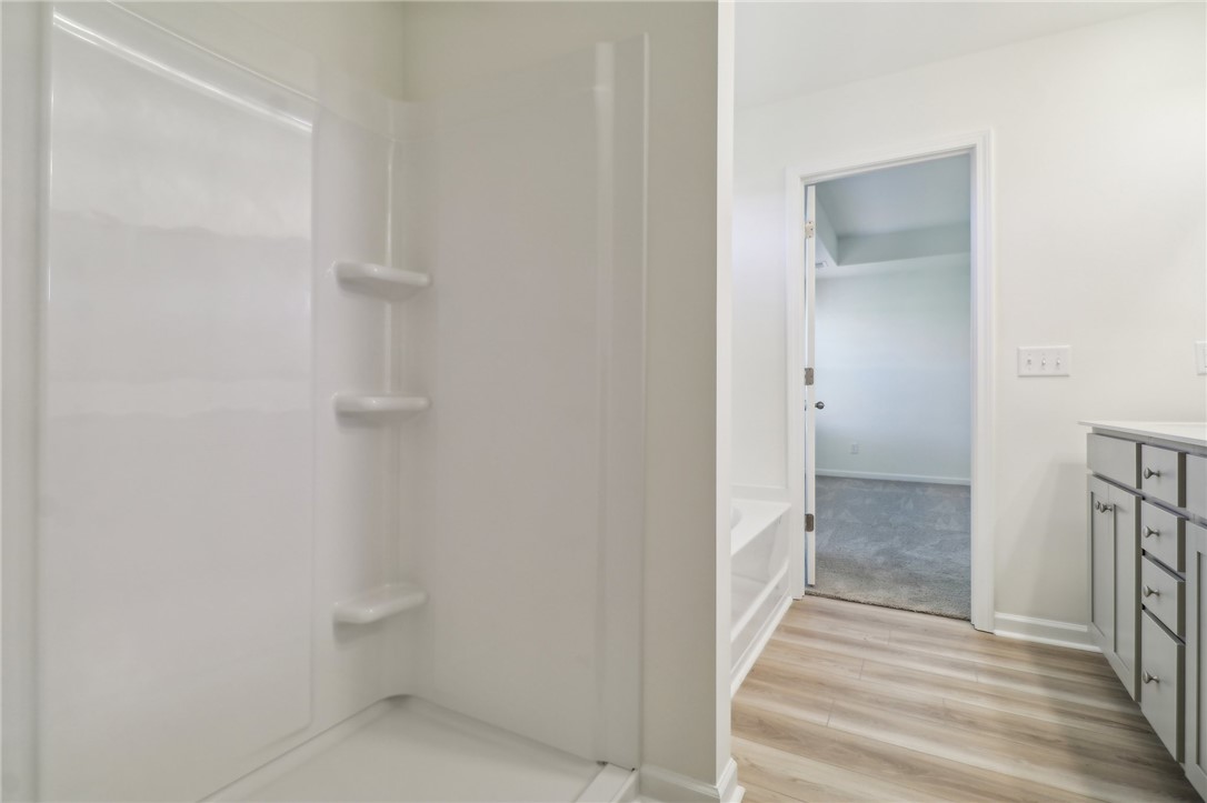 206 Bellflower Lane Pendleton, SC 29670 - Photo 21 of 27 This bright bathroom features a clean shower and sleek vanity, connecting seamlessly to a cozy bedroom.
