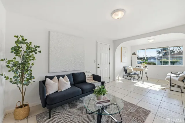 a living room with furniture and a potted plant