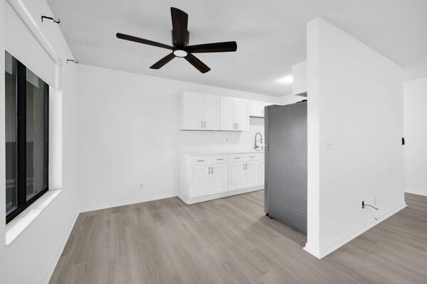 150 Pineview Road, Unit J6 Jupiter, FL 33469 - Photo 11 of 27 a view of empty room with wooden floor and ceiling fan