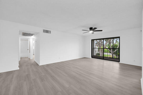 150 Pineview Road, Unit J6 Jupiter, FL 33469 - Photo 3 of 27 a view of an empty room with a window and wooden floor