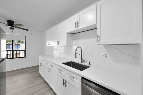 150 Pineview Road, Unit J6 Jupiter, FL 33469 - Photo 8 of 27 a kitchen with stainless steel appliances a sink and cabinets